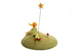 Le Petit Prince assis a coté de sa fleur